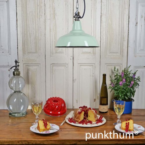 Apfelgrüne Emaille Industrielampe über dem Tisch, mit grauem Textilkabel.